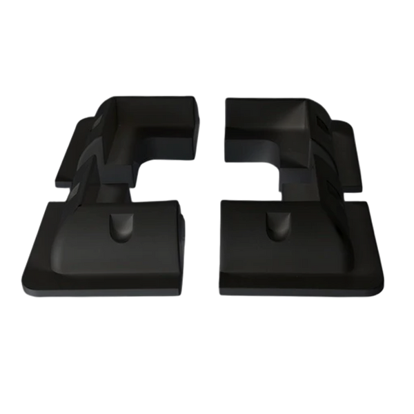 Four black ABS plastic solar panel corner brackets showing aerodynamic profile and internal mounting recesses