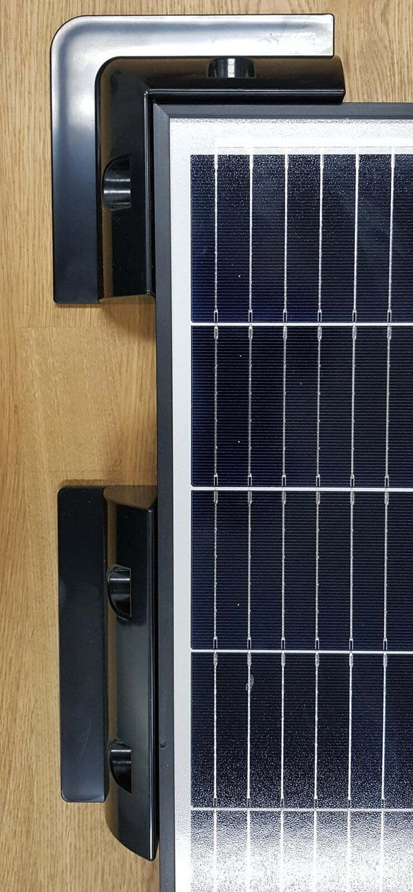 Top-down view of black corner and side brackets installed on a solar panel frame