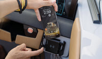 Smartphone mounted vertically in a wireless charger on a modern vehicle dashboard