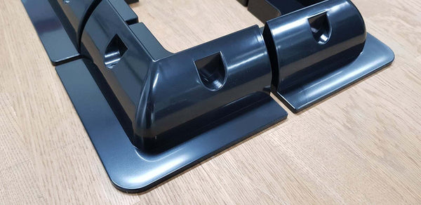 Close-up of black plastic corner bracket showing curved profile and recessed mounting holes