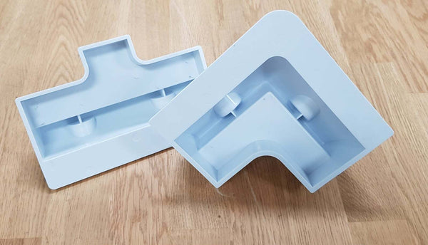 Underside view of corner mounting brackets revealing internal reinforcement ribs and adhesive surface area