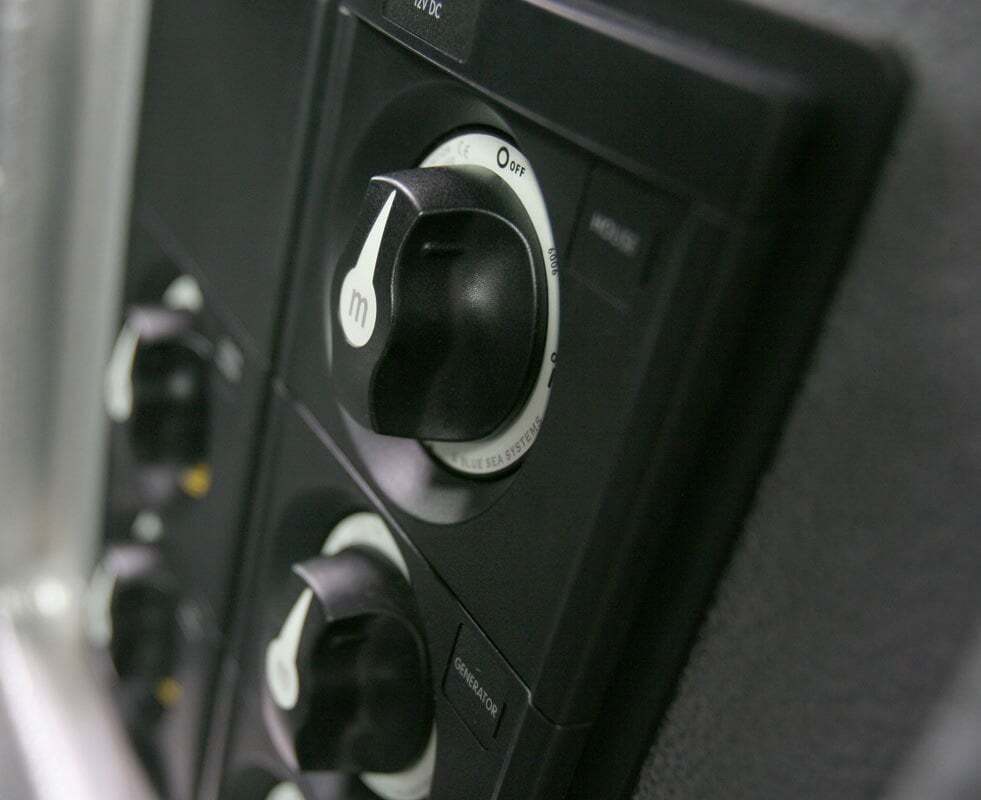 Angled close-up of battery switch mounted on dark control panel showing knob profile