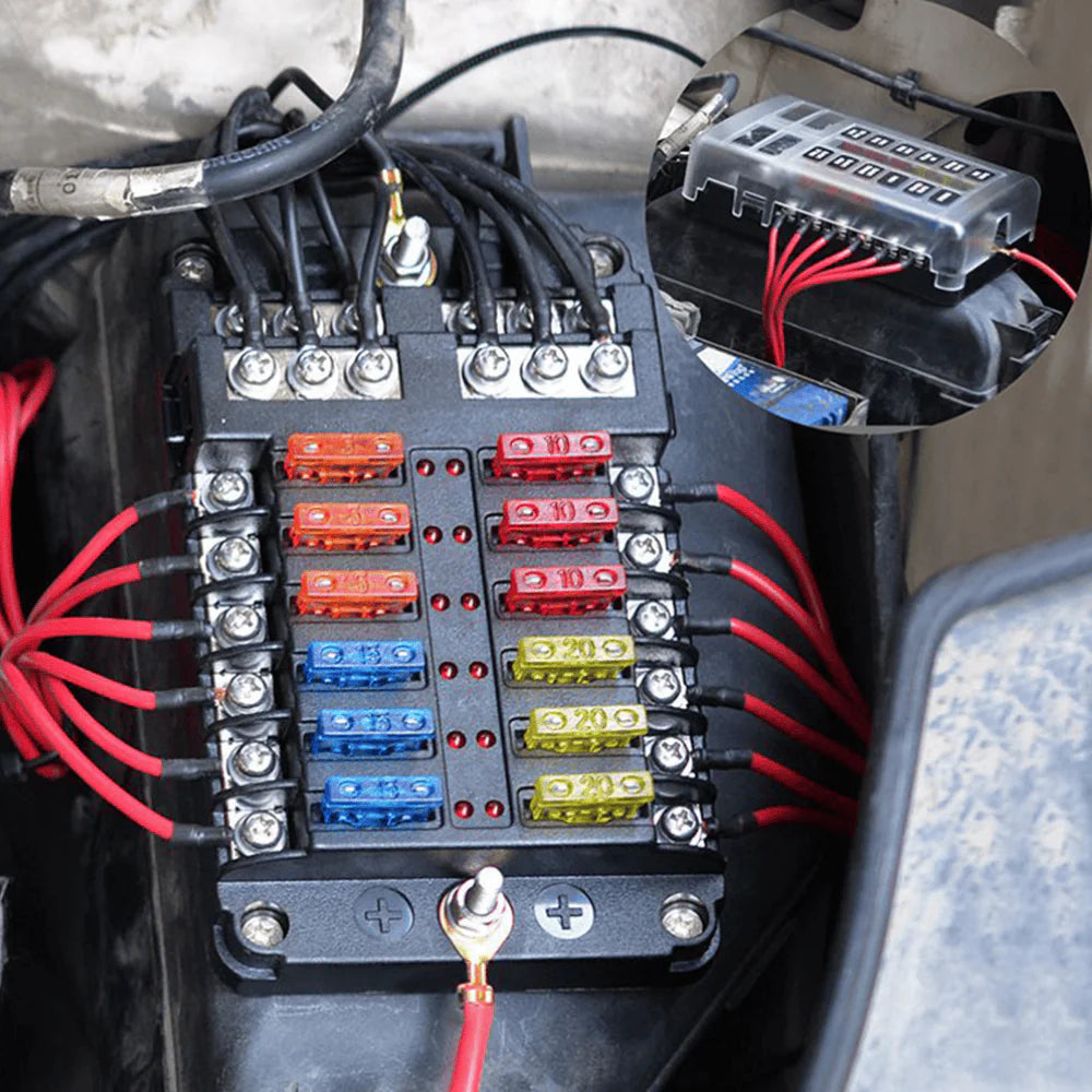 Close-up of 12-way fuse block installed in a vehicle engine bay with connected wiring
