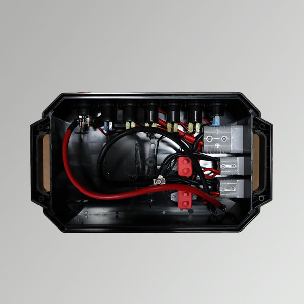 Top-down view inside open battery box showing heavy-gauge wiring, circuit breakers, and connector housings