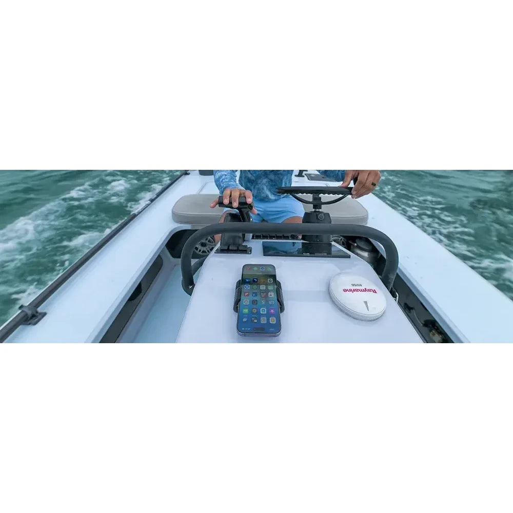 Lifestyle view of a smartphone charging in a marine-grade mount on a boat console