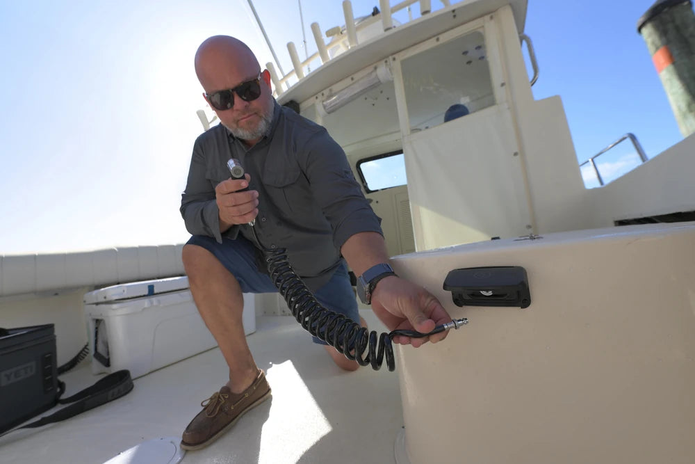 Man using the Scanstrut Ventura quick-connect water outlet on a boat
