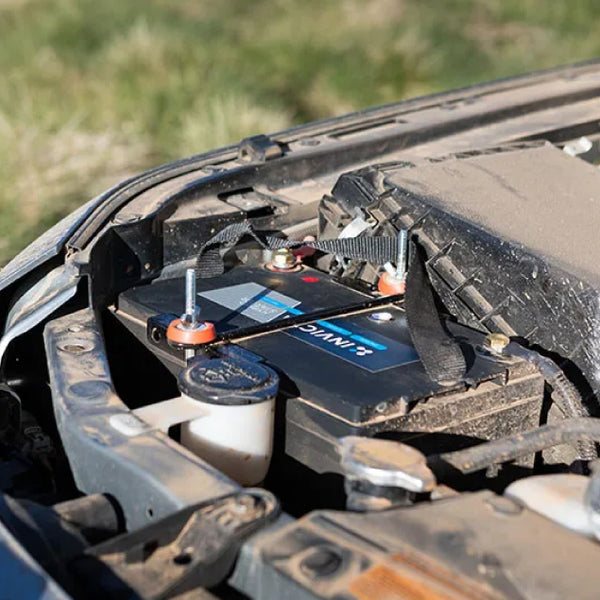 Invicta hybrid lithium battery installed in a vehicle engine bay with hold-down bracket