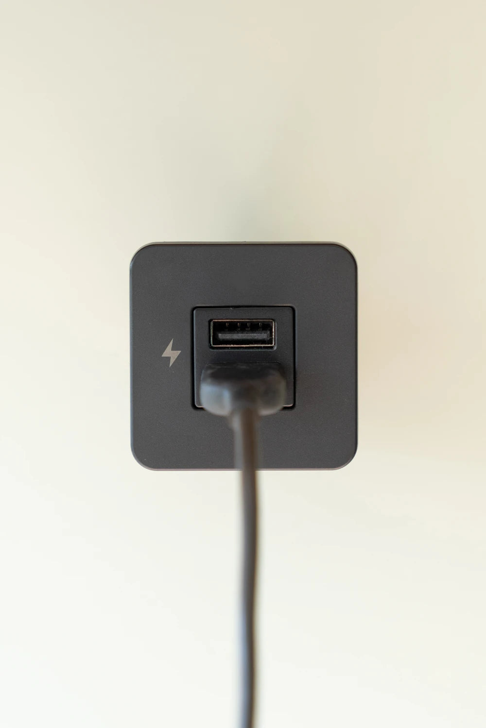 Close-up of a black USB-A charging socket with a power cable plugged in