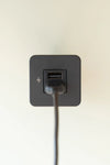 Close-up of a black USB-A charging socket with a power cable plugged in