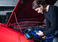 Victron smart charger connected to a red car battery under the bonnet