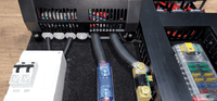 Detail view of the white AC consumer unit and cable routing at the bottom of the board