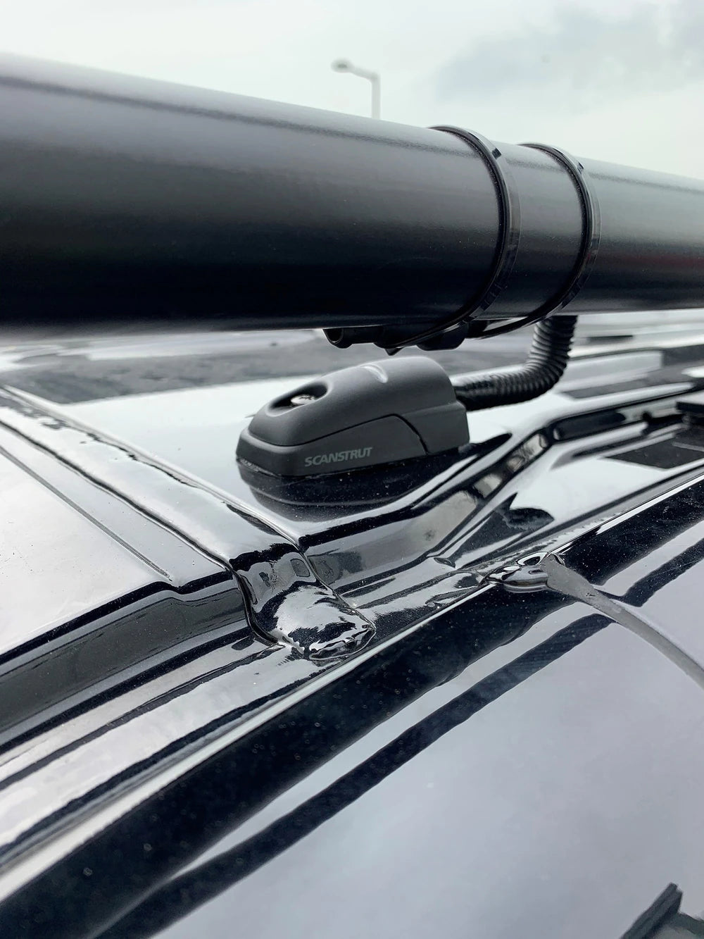 Scanstrut cable seal on a black vehicle roof routing protective conduit