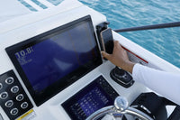 Hand placing a phone into the charger on a marine dashboard installation