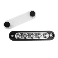 Overhead view of black busbar with five M6 studs and separate clear protective cover