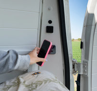 Magnetic wireless charger installed in a camper van wall with phone charging