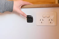 Black USB charger installed in a white caravan wall next to a power outlet