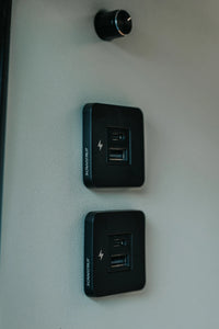 Two black Scanstrut TILE USB sockets mounted vertically on a campervan interior wall