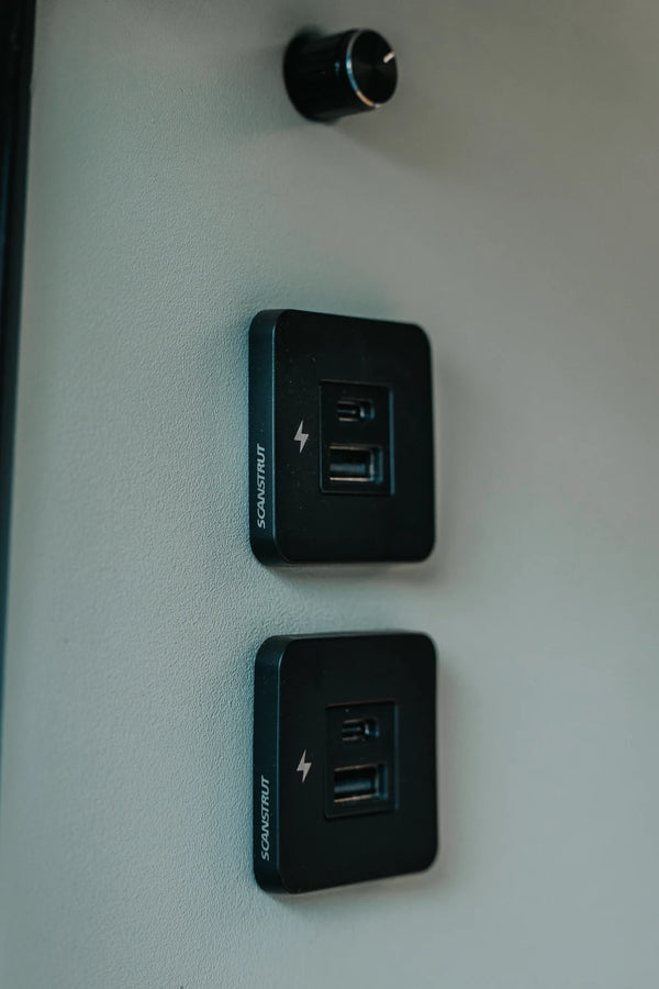 Two black Scanstrut TILE USB sockets mounted vertically on a campervan interior wall