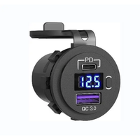 Angled view of black socket showing USB-C PD port, blue digital voltmeter, power button and QC 3.0 USB-A port