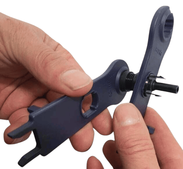 Close-up of hands using spanners to tighten a solar cable gland nut