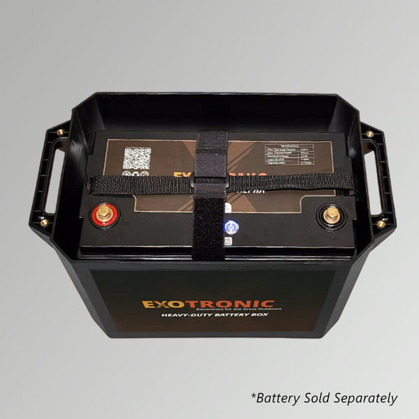 Top-down view into battery box showing heavy-duty strap securing the battery unit