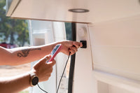 User plugging a charging cable into a Scanstrut TILE socket in a van conversion