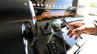 Marine wireless charger installed on a boat dashboard next to helm controls