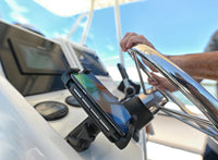 Waterproof wireless phone charger mounted on a boat console next to the steering wheel