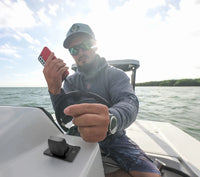 Marine lifestyle view of a phone being charged via the Flip Pro USB socket on a boat console