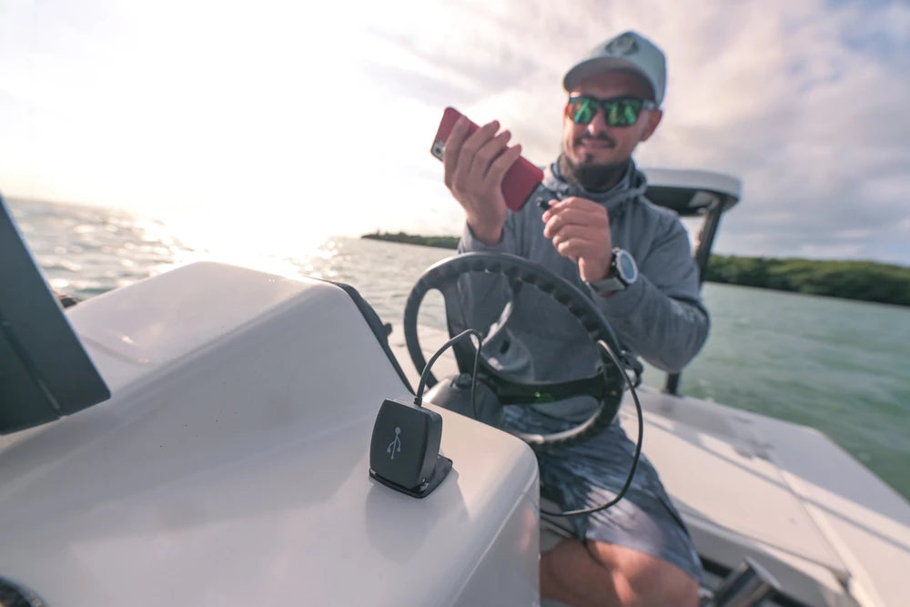 Man on a boat plugging a smartphone into a Scanstrut Flip Pro charger