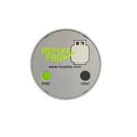 Top-down view of silver Mopeka Pro Check LPG sensor with green sync button and branding