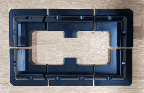 Overhead layout view of four corner brackets and two mid brackets arranged on a wooden surface
