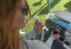 Hand placing a smartphone into the adjustable waterproof wireless charger on a utility vehicle