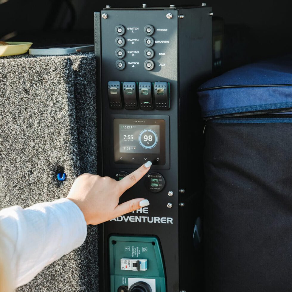 Hand operating the Simarine touch screen battery monitor on an Adventurer power system