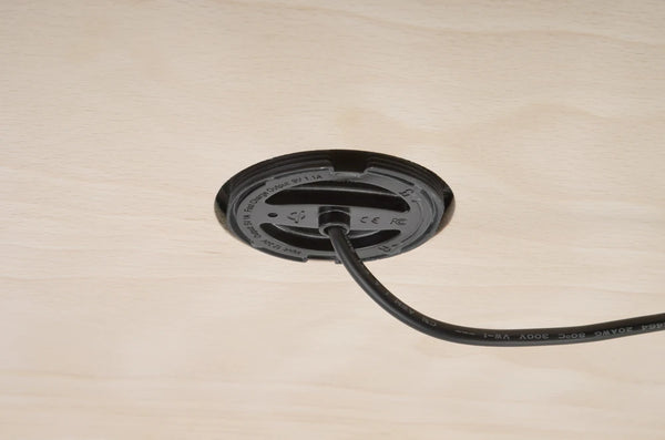Underside of recessed wireless charger showing mounting through timber panel