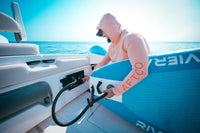 Man inflating a blue paddleboard using the Scanstrut ATMOS station installed on a boat deck