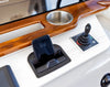 Integrated Aura wireless charger on a white marine dashboard with wood trim