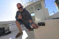 Man using the Scanstrut Ventura quick-connect water outlet on a boat