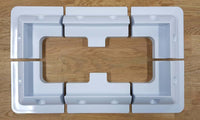 Top-down view of six-piece solar panel mounting kit arranged in rectangular formation on wooden surface