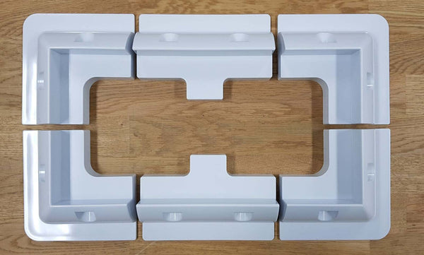 Top-down view of six-piece solar panel mounting kit arranged in rectangular formation on wooden surface