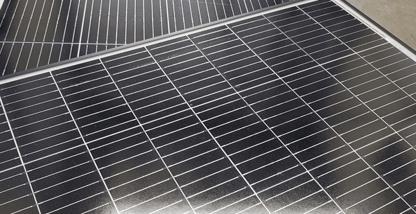 Macro detail shot of photovoltaic cells showing fine electrical grid lines on the panel surface