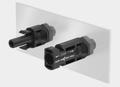Stäubli MC4 bulkhead connector pair mounted on a panel showing locking tabs and safety markings
