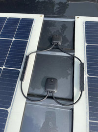 Top-down view of dual solar cable seal installation on a dark roof