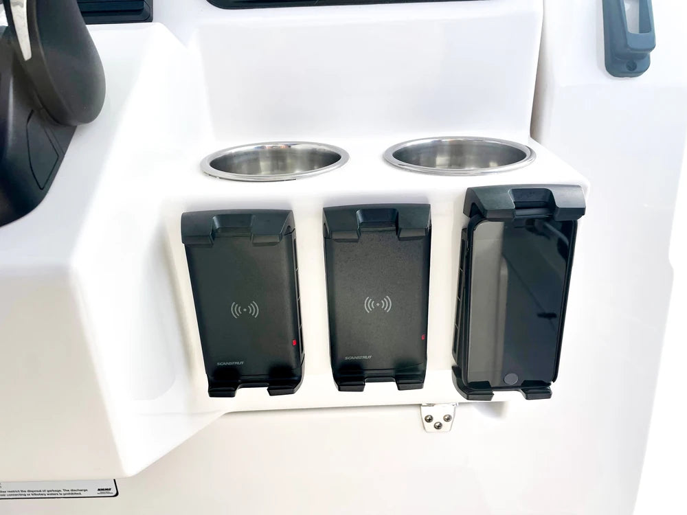 Three wireless chargers mounted in a row on a white boat helm