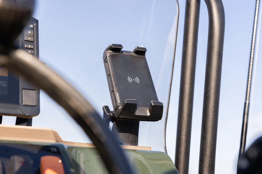 Wireless phone charger mounted on a vehicle dashboard for outdoor use