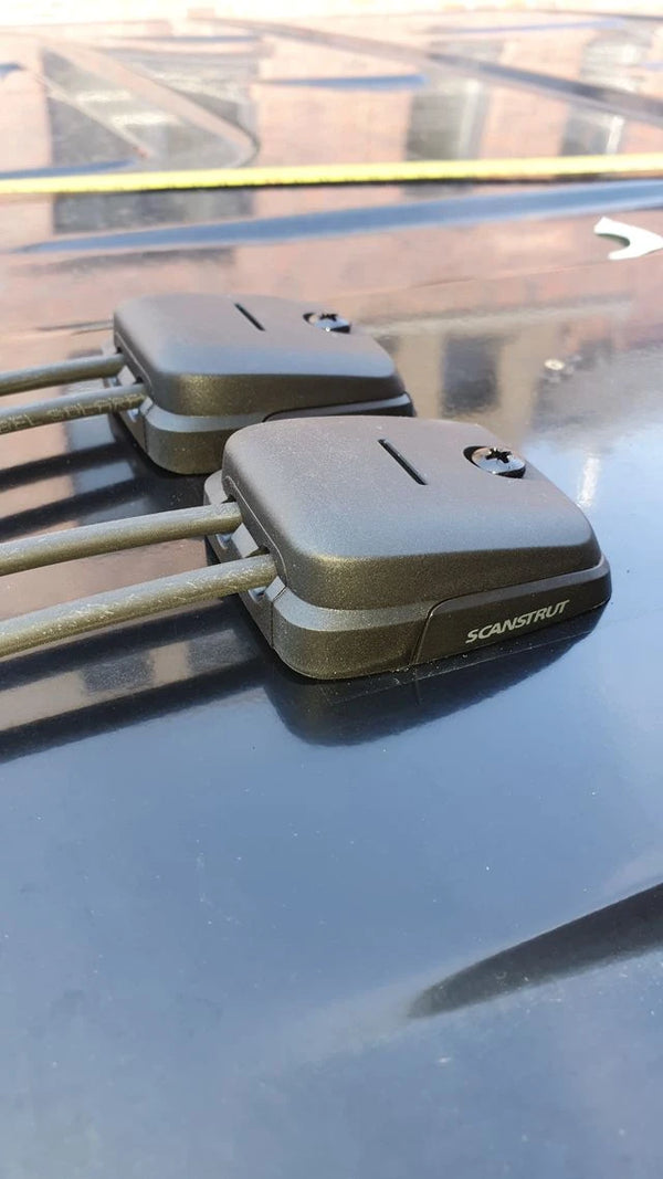 Side view of dual horizontal cable entry seals on a dark vehicle roof