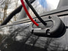 Black and red cables passing through a Scanstrut seal on a black vehicle roof