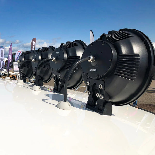 Row of spotlights on a white vehicle roof using grey waterproof cable seals