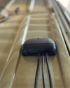 Close-up of a cable seal mounted on a vehicle roof with cables passing through the seal